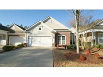 Charming home exterior features a two-car garage, brick accents, and landscaped yard at 136 Sabiston Ct, Cary, NC 27519