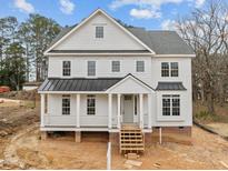 Beautiful two-story home with a covered porch and black accents against the white siding at 207 Holleman St, Apex, NC 27502