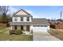 Charming two-story home with a two-car garage, manicured lawn, and inviting front porch at 210 Henry Steel Dr, Gibsonville, NC 27249