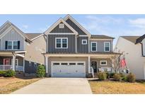 Charming two-story home featuring a two-car garage and inviting curb appeal with modern gray siding at 2404 Glade Mill Ct, Fuquay Varina, NC 27526