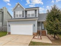 Charming two-story home with a well-maintained lawn, attached garage, and a welcoming entrance at 3809 Mardela Spring Dr, Raleigh, NC 27616