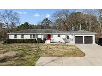 Charming one-story brick home features a red door, attached garage, and manicured landscaping at 4200 Us 1 Highway South, Kittrell, NC 27544