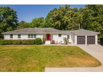 Charming, white-brick home with a well-manicured lawn and eye-catching red front door at 4200 Us 1 Highway South, Kittrell, NC 27544