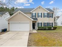 Charming two-story home features a two-car garage, blue shutters, and well-maintained landscaping at 5332 Seaspray Ln, Raleigh, NC 27610