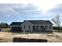 Charming single-story home featuring a neutral gray exterior, black shutters and a spacious attached garage at 56 N Movado Trl, Kenly, NC 27542