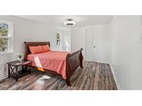 Bright bedroom features new flooring, a ceiling fan, and a wooden sleigh bed with soft pillows at 608 N 15Th St, Erwin, NC 28339