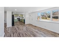 Bright living room featuring wood flooring, a front door, and a large window for natural light at 608 N 15Th St, Erwin, NC 28339
