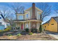 Charming two-story home with a brick chimney, inviting front porch, and a beautiful garden area at 611 S Buchanan Blvd, Durham, NC 27701