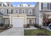Charming townhome with a one-car garage, gray accents, and a welcoming front entrance at 63 Pale Moss Dr, Clayton, NC 27527