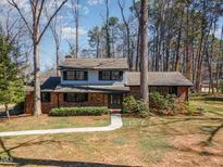 Charming two-story home with brick facade, black shutters and mature trees at 6600 Clinton Pl, Raleigh, NC 27607