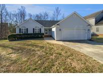 Charming single-story home featuring a manicured lawn, arched windows, and a two-car garage at 6624 Professor St, Raleigh, NC 27616