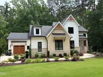 Charming two-story home featuring a brick and siding exterior with a lush green lawn at 6816 Rainwater Rd, Raleigh, NC 27615
