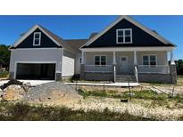 Charming home featuring a two-car garage, covered porch, and classic architectural details at 896 Olive Branch Dr, Smithfield, NC 27577