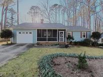 Charming home featuring a screened porch, lush lawn and well-maintained landscaping at 103 Black Bear Ct, Cary, NC 27513