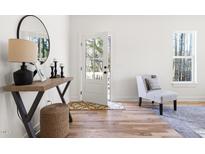 Bright entryway with hardwood floors, modern decor, and natural light from the window and open front door at 1031 W Murray Ave, Durham, NC 27704