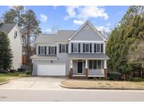 Charming two-story home featuring a covered front porch, manicured lawn, and attached two-car garage at 104 Rosenberry Hills Drive Dr, Cary, NC 27513