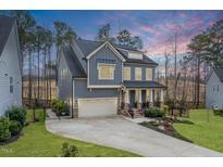 Beautiful craftsman home with a well-manicured lawn, 2-car garage and covered front porch at 105 Mystic Quartz Ln, Holly Springs, NC 27540