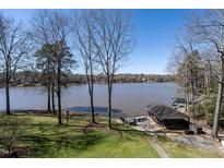 Picturesque lake view from the backyard with mature trees and a boat dock at 106 Nashua Cv, Louisburg, NC 27549
