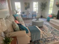 Bright living room featuring a comfy couch, area rug, and decor at 1208 Turner Farms Rd, Garner, NC 27529