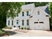 Charming two-story brick home with a light-colored roof, manicured landscaping, and an attached two-car garage at 1222 Dixie Trl, Raleigh, NC 27607