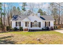 Charming single-story home featuring a well-manicured lawn, dark shutters, and a classic white exterior at 15 Browning Ct, Clayton, NC 27520