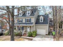 Charming two-story home featuring a front porch, attached garage, dormer windows, and traditional design elements at 1701 Point Owoods Ct, Raleigh, NC 27604