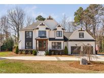 Charming two-story home with white brick, decorative gables, and a well-manicured lawn at 206 Torrey Pines Dr, Cary, NC 27513