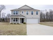 Charming two-story home featuring a well-manicured lawn, a two-car garage, and a welcoming front porch at 2121 Wildwind Dr, Graham, NC 27253