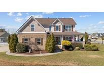 Charming two-story home featuring a brick facade, welcoming front porch, and manicured landscaping at 22 Old York Cir, Clayton, NC 27527