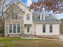 Charming two-story home featuring a stone facade and inviting entrance with beautiful architectural details at 3525 La Costa Way, Raleigh, NC 27610