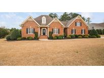 Beautiful brick home with a manicured lawn and mature landscaping showcasing classic curb appeal at 4017 Olde Waverly Way, Fuquay Varina, NC 27526