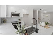 Bright kitchen with stainless steel appliances, white cabinetry, and a modern faucet overlooking the entry at 4307 Pope Rd, Durham, NC 27707