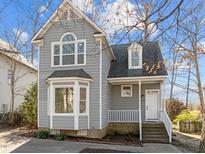 Charming gray two-story home featuring a welcoming front porch and attractive architectural details at 4929 Liverpool Ln, Raleigh, NC 27604