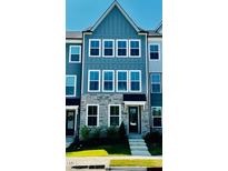 Charming townhome with a stone facade and light blue vertical siding at 526 Billingshurst Way # 211, Knightdale, NC 27545