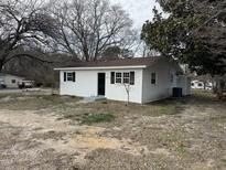 Quaint one-story home featuring a clean white exterior and classic black shutters at 590 Industrial Dr, Wendell, NC 27591