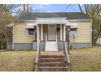 Charming single Gathering home featuring a quaint covered porch, white columns, and brick steps leading to the front entrance at 617 Bernice St, Durham, NC 27703