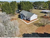 Charming single-story home with a large yard and a cozy front porch surrounded by mature trees at 6617 Rock Service Station Rd, Raleigh, NC 27603