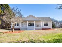 Charming single-story home with a welcoming front porch, manicured lawn, and bright natural light at 6617 Rock Service Station Rd, Raleigh, NC 27603