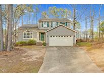 Charming two-story home featuring green shutters, a two-car garage, and a well-maintained front yard with mature trees at 7 Indian Head Ct, Durham, NC 27703
