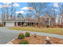 Stunning exterior view of home with a long driveway and beautiful landscaping, perfect for serene living at 95 Blueberry Rdg, Pittsboro, NC 27312