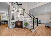 Bright foyer features hardwood floors, elegant staircase with white railings, and tasteful decor at 105 Aberson Ct, Cary, NC 27519