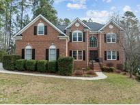 Charming two-story brick home with manicured lawn and classic architectural details at 105 Aberson Ct, Cary, NC 27519
