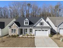 Charming home featuring stone accents, dormer windows, and a well-manicured front yard at 131 English Violet Ln, Raleigh, NC 27610