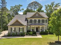 Charming two-story home with a manicured lawn, inviting porch, and lush, mature landscaping at 1328 Mill Glen Cir, Raleigh, NC 27614