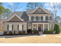 Charming home featuring a welcoming covered porch, manicured landscaping, and elegant architectural details at 1328 Mill Glen Cir, Raleigh, NC 27614