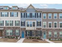 Charming townhomes with stone accents, colorful front doors, and coordinated shutters, offering a welcoming curb appeal at 1329 Channing Park Cir, Cary, NC 27519