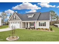 Charming single-Gathering home featuring a two-car garage, beautifully landscaped yard, and inviting front porch at 137 Shadybrook Dr, Benson, NC 27504