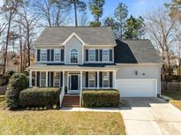Charming two-story home features a well-manicured lawn, attached garage, and classic shutters at 14 Gingerwood Ln, Durham, NC 27713