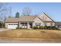 Charming single-story home with attached garage, landscaped yard, and inviting front porch at 16 Eagle Swoop St, Zebulon, NC 27597