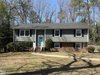 Charming two-story home with a blue door, black shutters and a well-maintained front yard at 1816 Phillips Dr, Sanford, NC 27330
